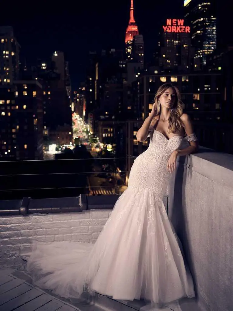 A woman in white dress standing on top of a building.