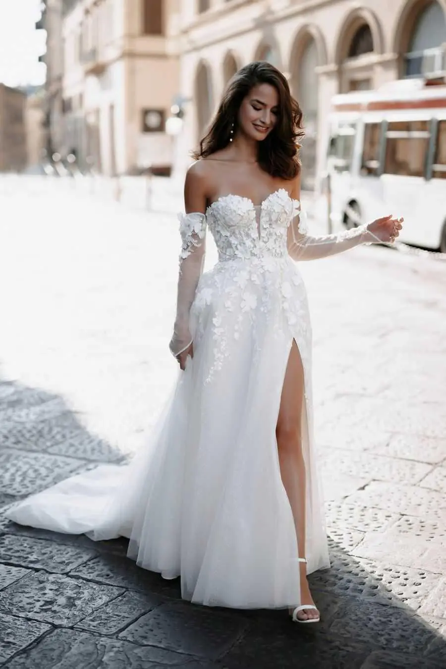 A woman in white dress standing on the street.