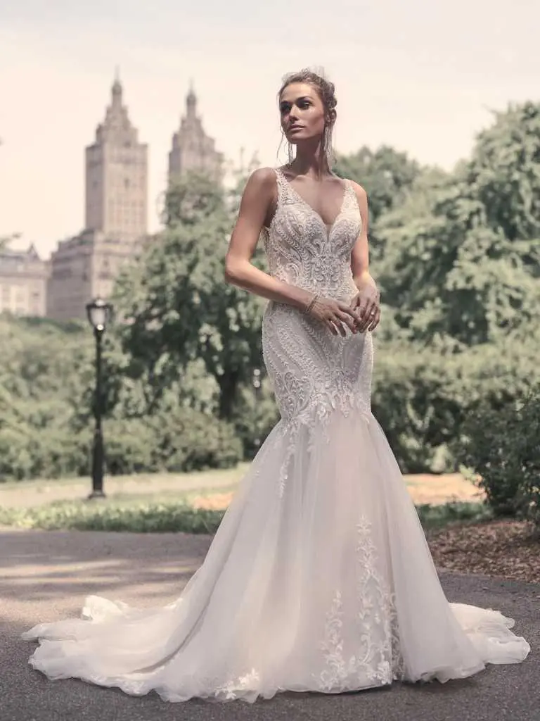 A woman in a white dress standing on the street.