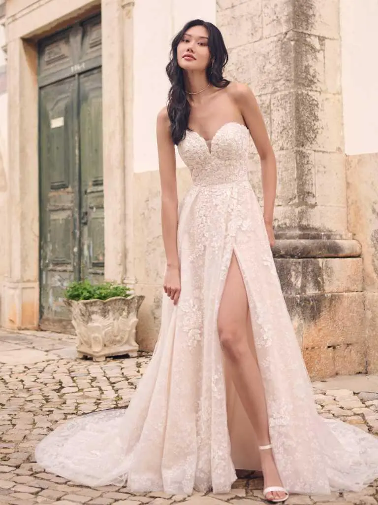 A woman in a white dress standing on the street.