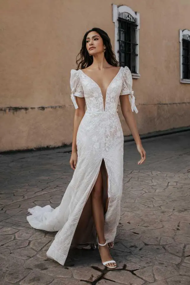 A woman in a white dress standing on the street.