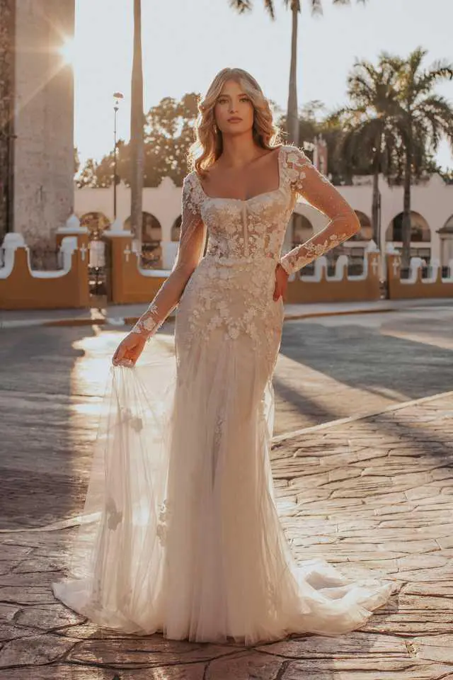 A woman in a white dress standing on the street.