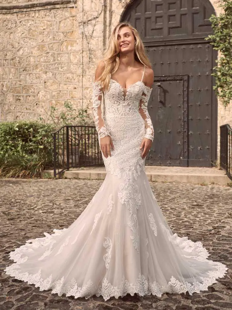 A woman in a wedding dress standing on the street.