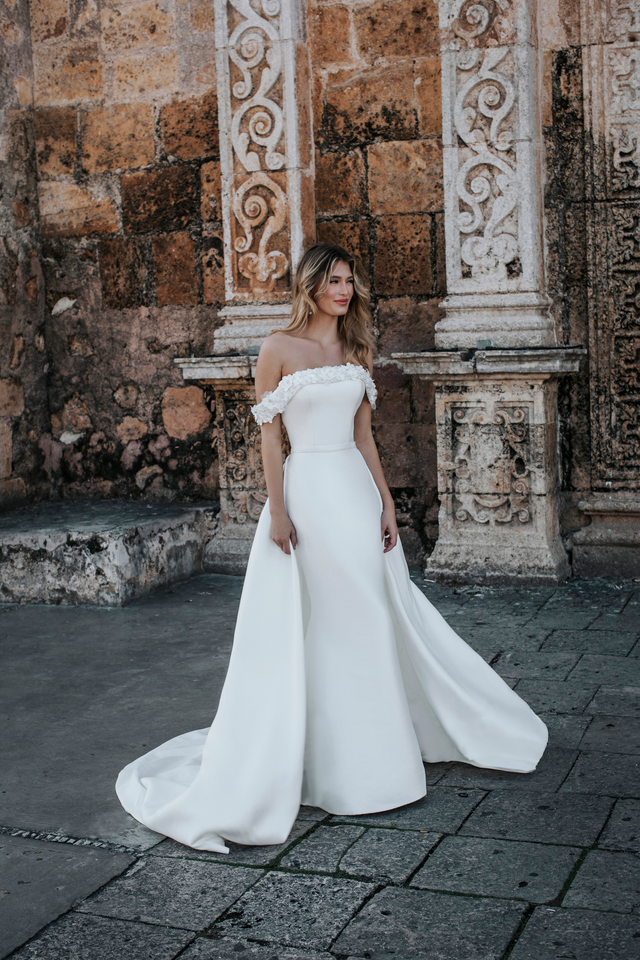 A woman in a white dress standing on the street.