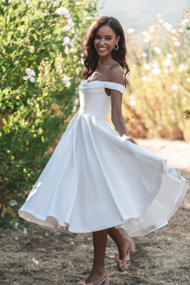 A woman in white dress standing on top of a tree.