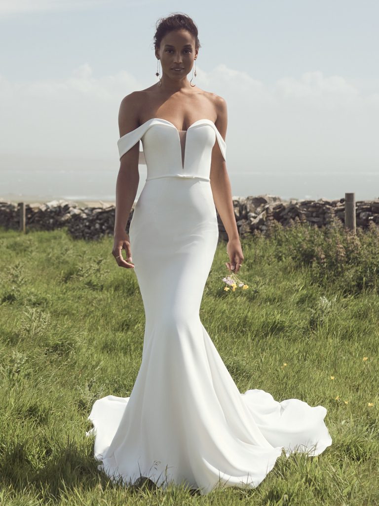 A woman in white dress standing on top of grass.